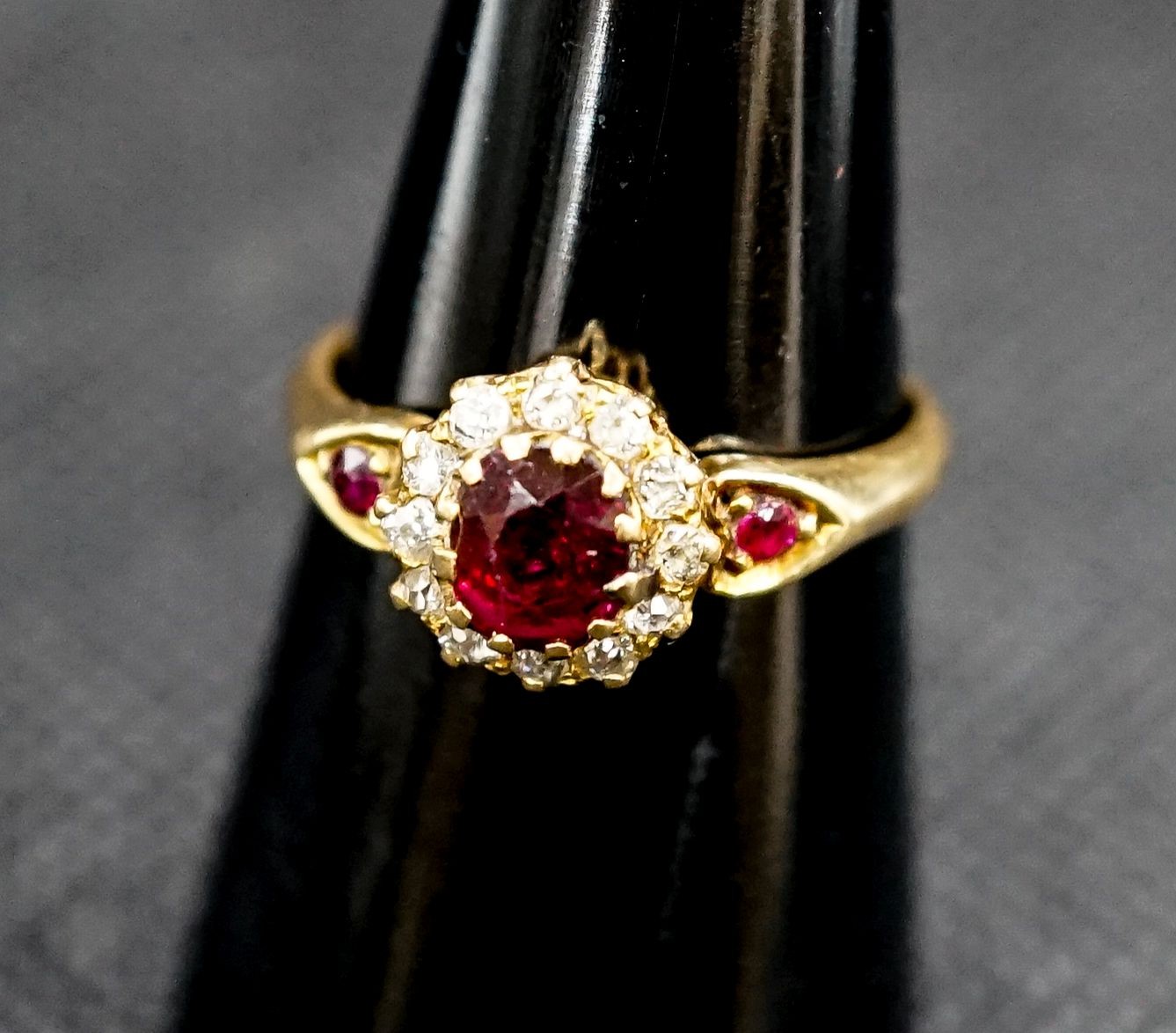 A late Victorian 18ct gold ruby and diamond cluster ring, with ruby set shoulders, size M, gross weight 2.7 grams.